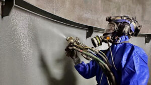 Person som sprejar polyuretan på vägg